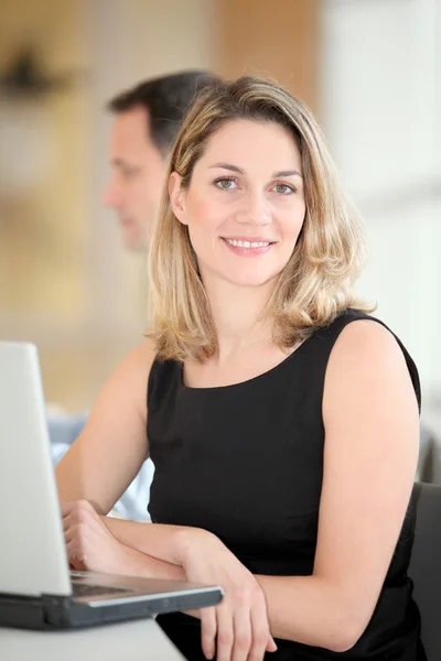 Empresária sentada no escritório em frente ao laptop — Fotografia de Stock