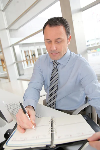 Portrait of salesman writing on agenda — Stock Photo, Image