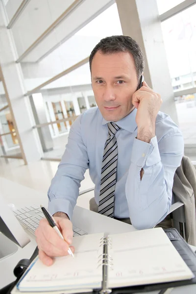 Affärsman på telefonen skriva på dagordningen — Stockfoto