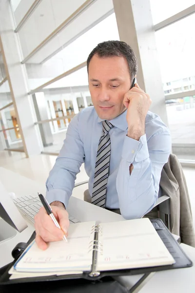 Affärsman på telefonen skriva på dagordningen — Stockfoto