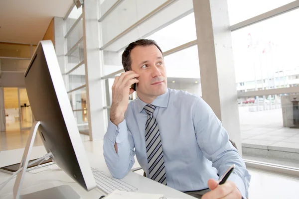 Businessman on the phone writing on agenda — Stock Photo, Image