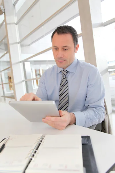 Uomo d'affari seduto in ufficio con tablet elettronico — Foto Stock