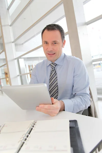 Zakenman zit in het kantoor met elektronische tabblad — Stockfoto