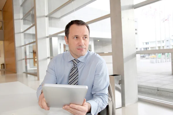 Biznesmen siedząc w biurze z elektronicznych tabletki — Zdjęcie stockowe