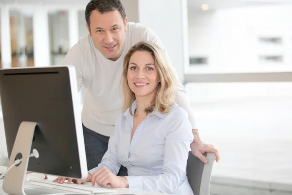 Office workers in front of desktop computer — Stock Photo, Image