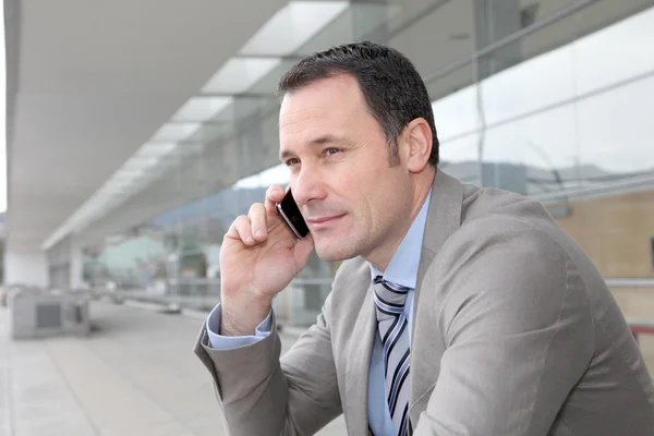 Πωλητής μιλώντας στο τηλέφωνο έξω από το συνεδριακό κέντρο — Φωτογραφία Αρχείου