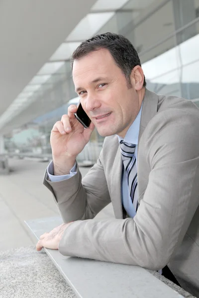Salesman talking on the phone outside congress center — Stock Photo, Image