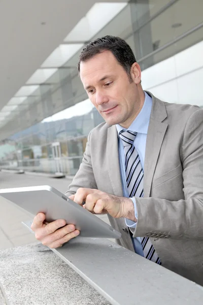 Businessman using electronic tab outside congress center — Stock Photo, Image