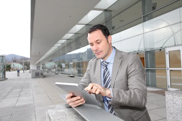 Uomo d'affari utilizzando scheda elettronica al di fuori del centro congressi — Foto Stock