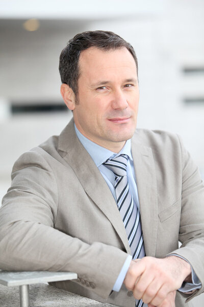 Бизнесмен, стоящий за пределами офиса
