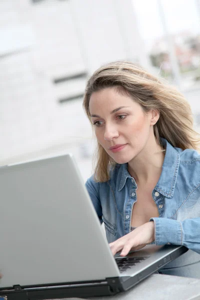 Vrouw met laptopcomputer in de straat — Stockfoto