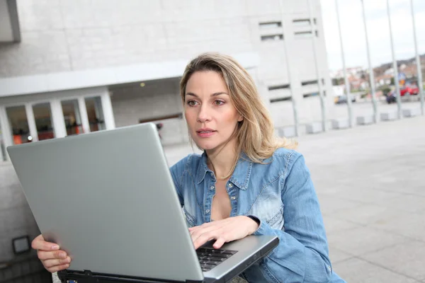 Mujer usando ordenador portátil en la calle — Foto de Stock
