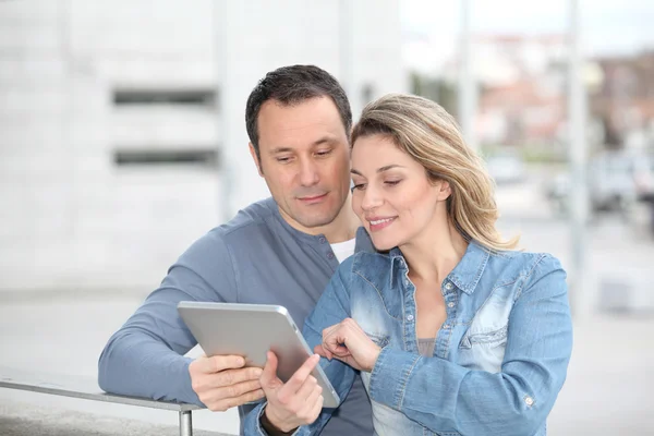 Couple using electronic tab in the street — Stock Photo, Image