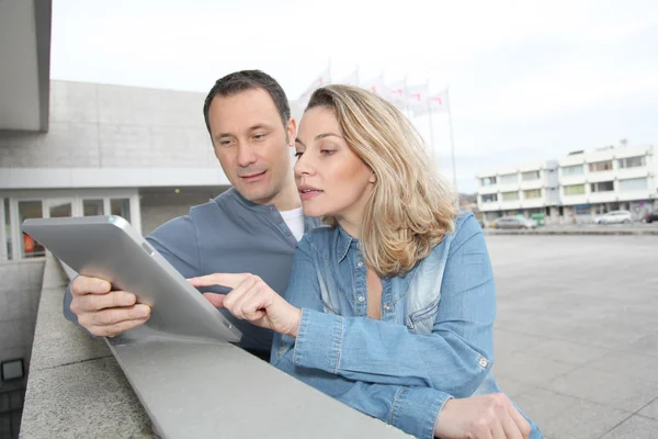 Paar benutzt elektronische Registerkarte auf der Straße — Stockfoto
