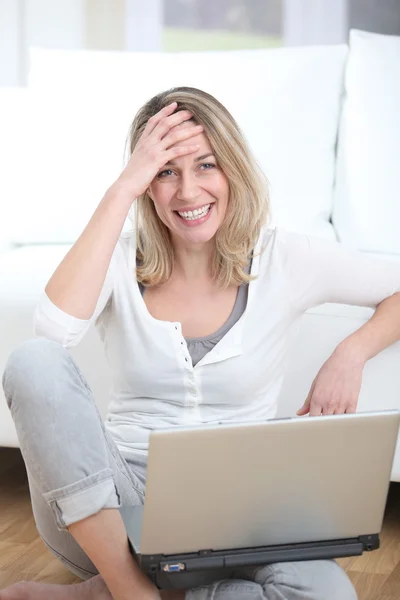 Ευτυχισμένη γυναίκα χρησιμοποιώντας φορητό υπολογιστή στο σπίτι — Φωτογραφία Αρχείου