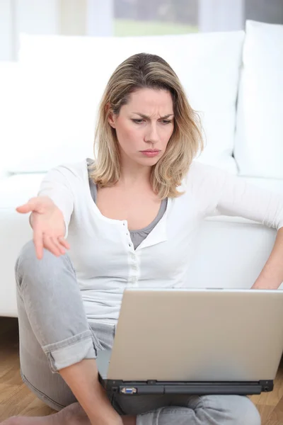 Mulher com olhar pensativo usando computador portátil — Fotografia de Stock