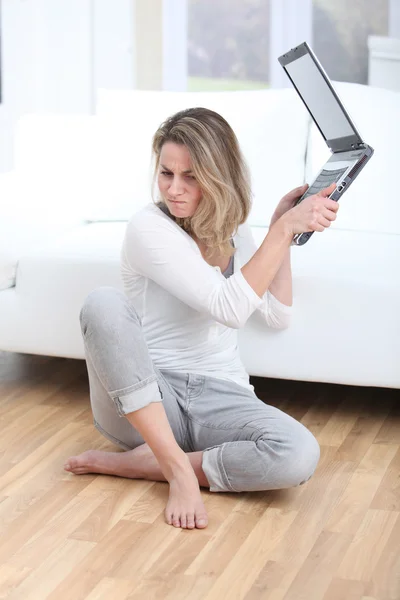 Donna bionda che lancia computer portatile sul pavimento — Foto Stock