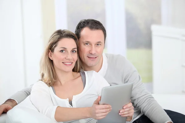 Couple sitting in sofa with electronic tab — Stock Photo, Image
