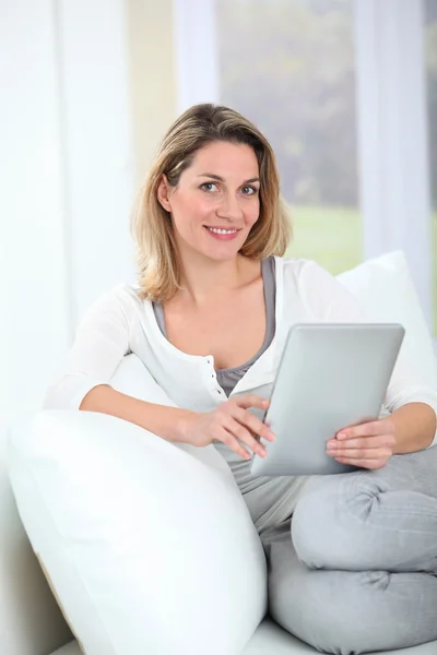 Frau sitzt mit elektronischem Tablett auf Couch — Stockfoto