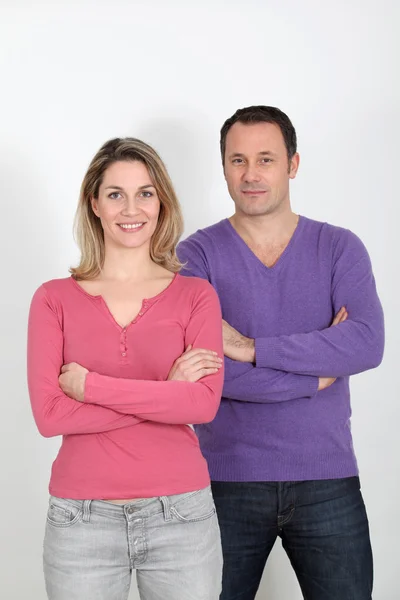 Couple standing on white background with arms crossed — Stock Photo, Image