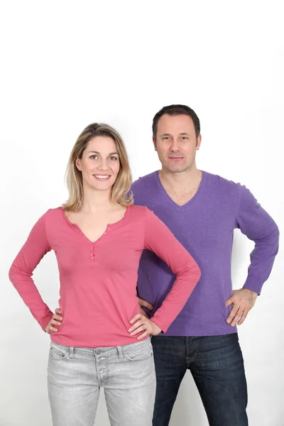 Paar steht auf weißem Hintergrund mit den Händen auf den Hüften — Stockfoto