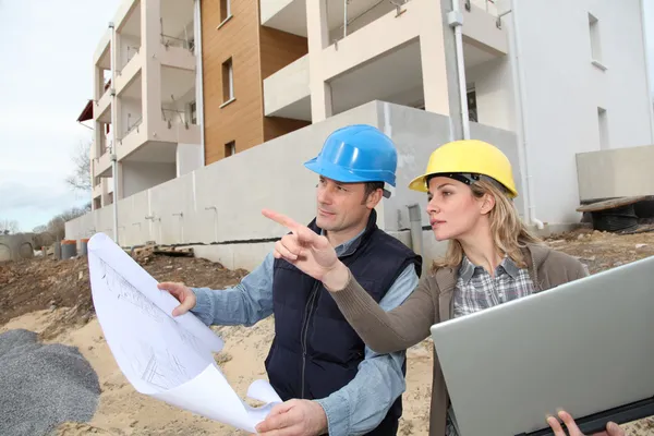 建筑师和工程师看建筑施工现场的计划 — 图库照片