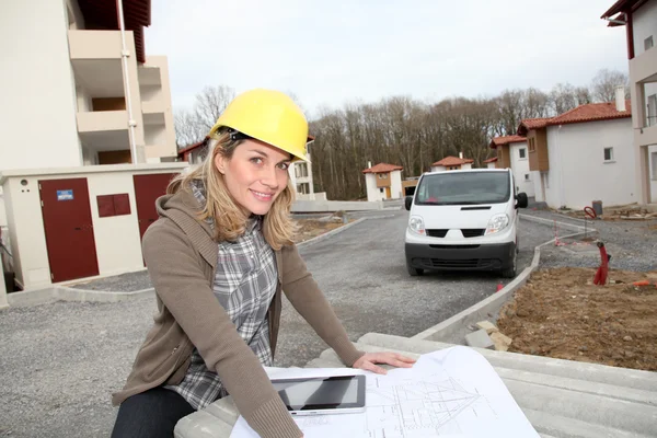 Inżynier kobieta, patrząc na plan budowy — Zdjęcie stockowe