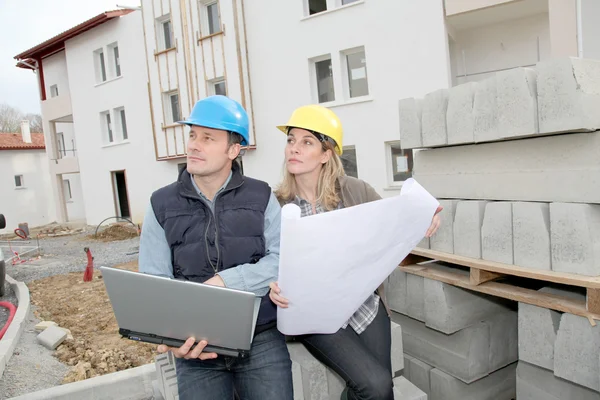 Architect and engineer looking at plan on construction site — Stock Photo, Image