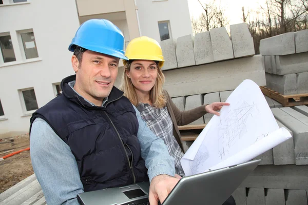 Arquiteto e engenheiro olhando para o plano no canteiro de obras — Fotografia de Stock