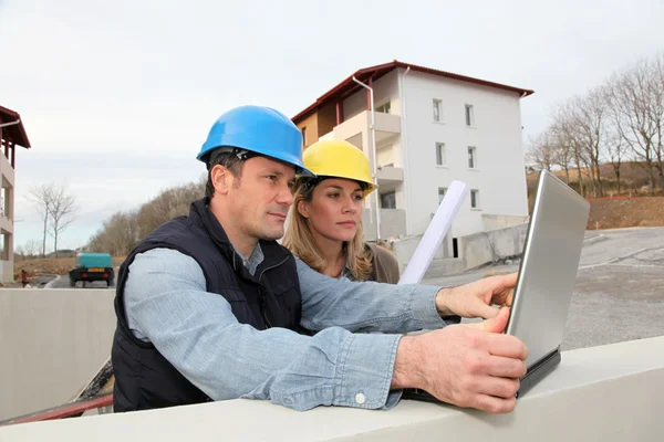 建筑师和工程师看建筑施工现场的计划 — 图库照片