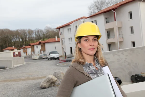 Žena inženýr s bezpečnostní přilbou stojící na staveništi — Stock fotografie