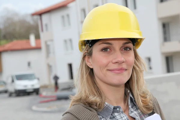 与安全头盔站在建筑工地上的女工程师 — 图库照片