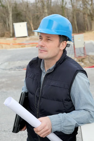 Supervisor do local com capacete de segurança em pé no local de construção — Fotografia de Stock