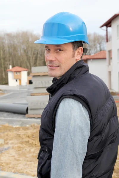 Site Yöneticisi ile inşaat alanı üzerinde güvenlik kask duran — Stok fotoğraf