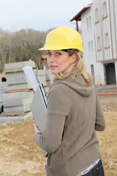 与安全头盔站在建筑工地上的女工程师 — 图库照片