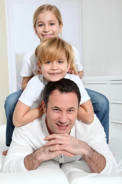 Retrato de padre e hijos acostados en sofá —  Fotos de Stock