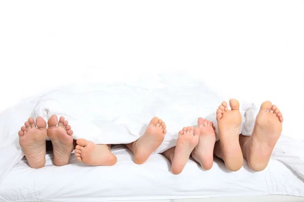 Fechar os pés da família na cama — Fotografia de Stock