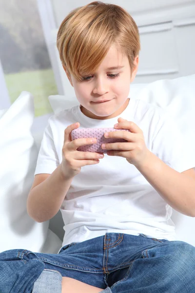 Portret van kleine blonde jongen afspelen van video game — Stockfoto