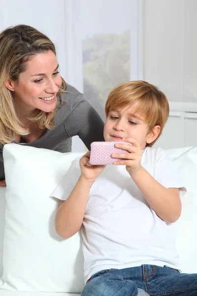 Mor och son spela videospel på telefon — Stockfoto