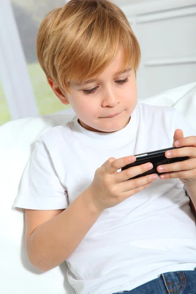Retrato de un niño rubio jugando videojuego — Foto de Stock