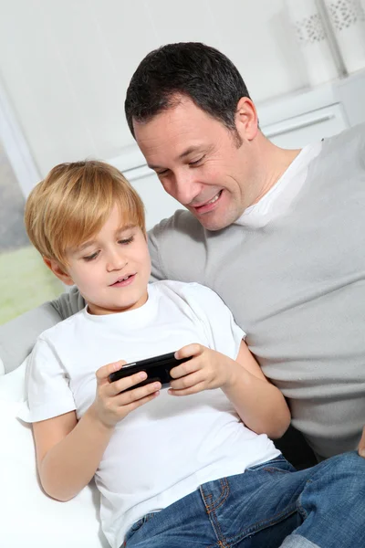 父子俩在家里玩电子游戏 — 图库照片