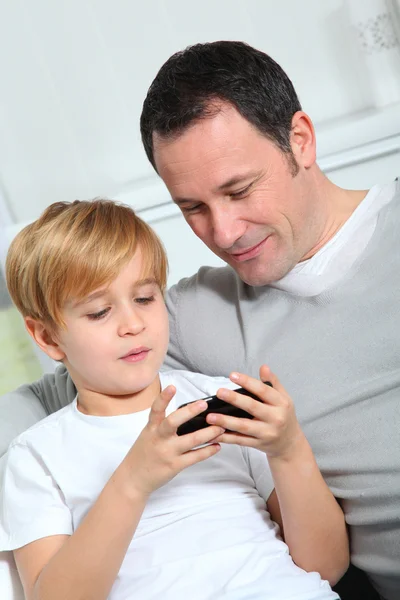 Отец и сын играют в видеоигры дома — стоковое фото