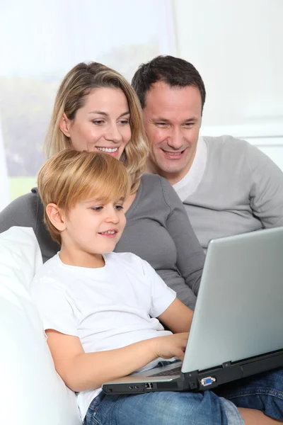 Los padres y el niño en casa con ordenador portátil — Foto de Stock