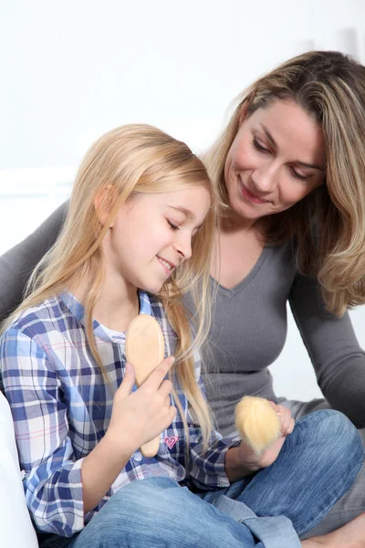 Mother and daughter playing with doll — Stock Photo, Image