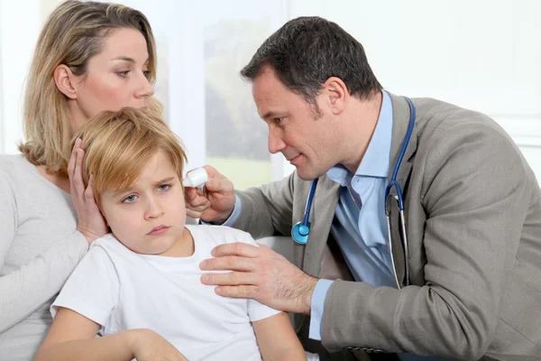 Arzt tröstet kleinen Jungen über Ohrenentzündung — Stockfoto