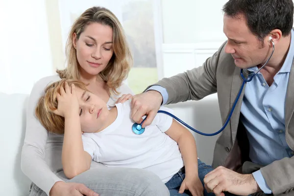 Médico examinando menino doente — Fotografia de Stock