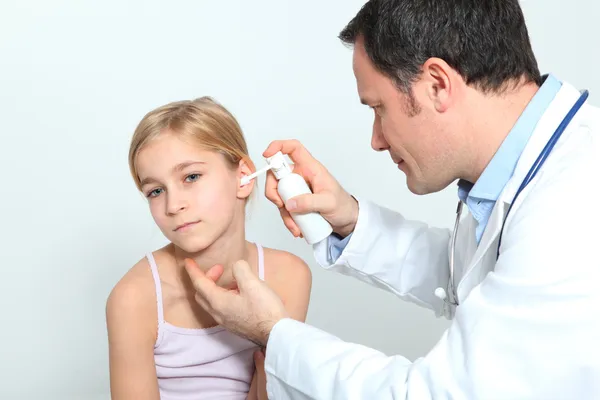 Arzt behandelt kleine Mädchen mit Ohrinfektion — Stockfoto