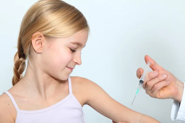 Médico fazendo injeção de vacina para a menina loira — Fotografia de Stock