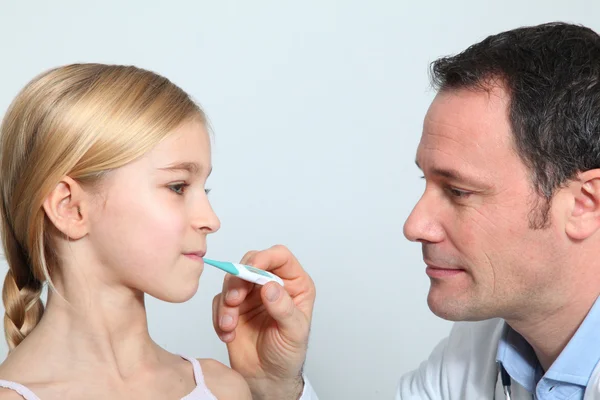 Lekarz sprawdzanie dziewczynka temperatury — Zdjęcie stockowe