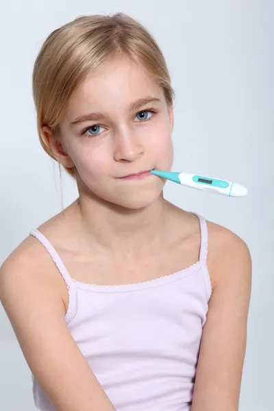 Портрет маленькой девочки с термометром во рту — стоковое фото